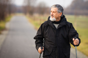 After workout stretches Senior man nordic walking, enjoying the outdoors